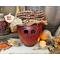 This is a fall apple decoration. It is a real gourd with a happy face  carved into it. This gourd is named Mac and has a lacy handmade hat